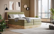 Modernes Boxspringbett in einem stilvollen Schlafzimmer mit grüner Polsterung und Holzdetails, seitliche Perspektive