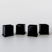 Vier schwarze quadratische Metallfüße für einen Midischrank, frontal betrachtet auf hellem Hintergrund.