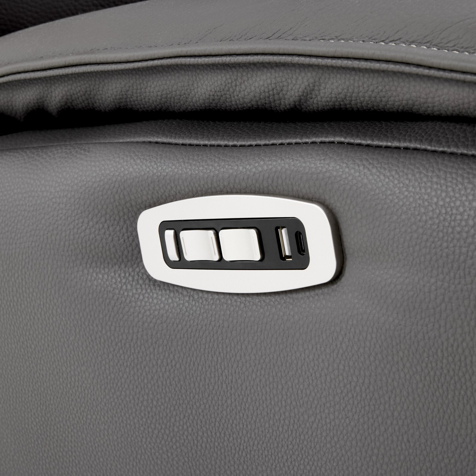 Nahaufnahme aus seitlicher Perspektive auf das Bedienfeld eines grauen Polstermöbels mit Verstelltasten sowie USB-A- und USB-C-Anschluss