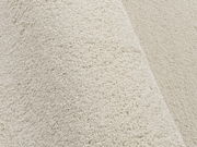 Nahaufnahme eines cremefarbenen Uni-Teppichs mit weicher Textur, seitliche Perspektive