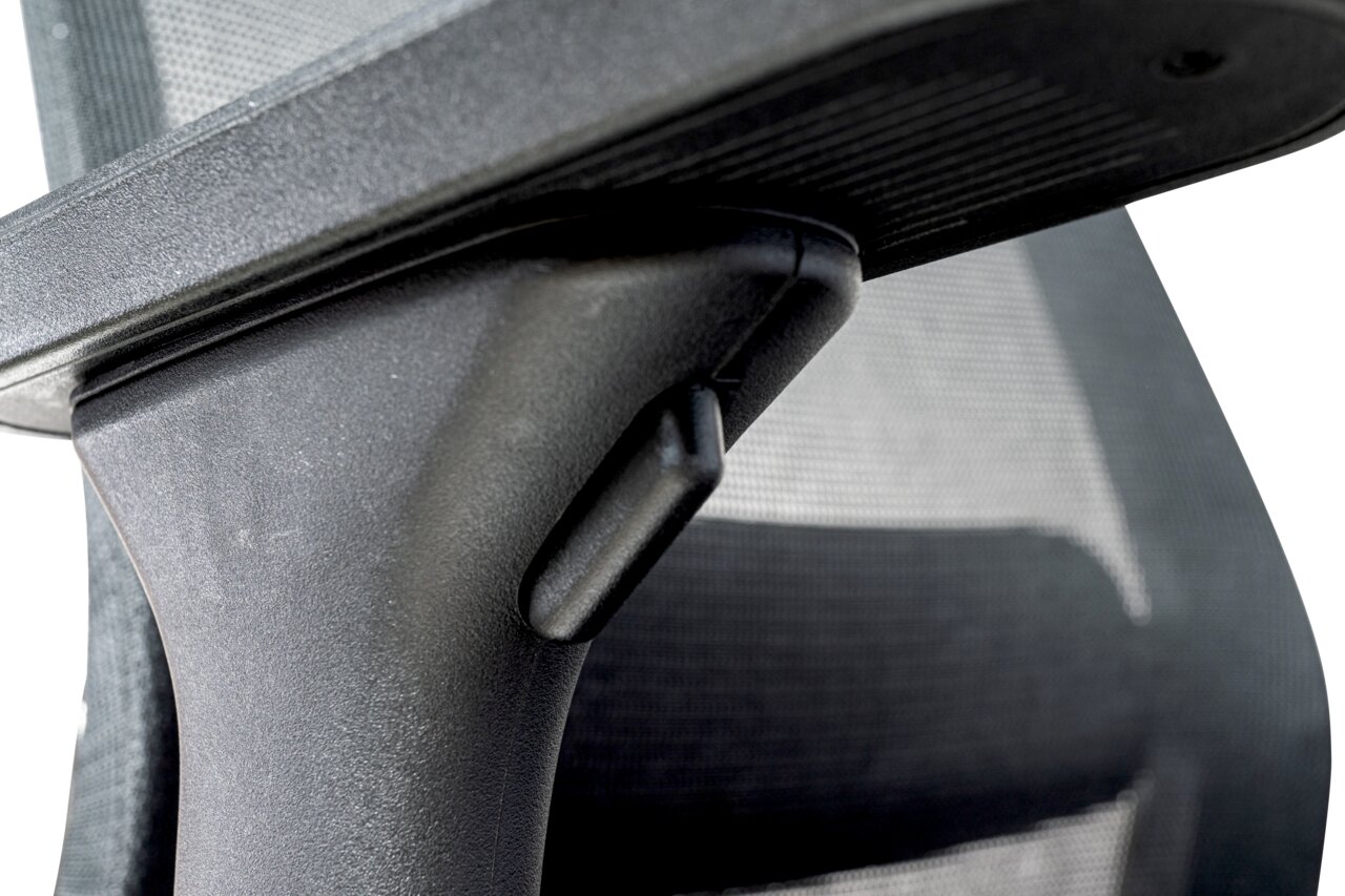 Nahaufnahme eines Drehstuhls mit Fokus auf die Armlehne und den Netzrücken, seitliche Perspektive.