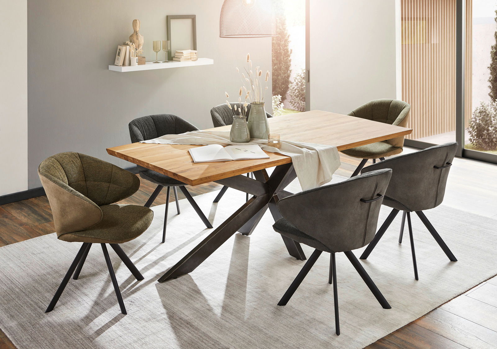 Moderner Esstisch mit Holzplatte und schwarzen Metallbeinen, umgeben von stilvollen Stühlen in einem hellen Esszimmer. Perspektive von schräg oben.