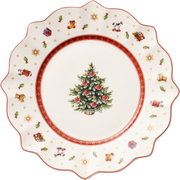 Weißer Frühstücksteller mit weihnachtlichem Design, zentralem Weihnachtsbaum und bunten Motiven am Rand, von oben betrachtet.