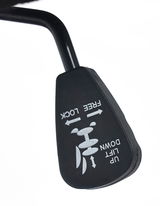 Nahaufnahme eines Hebels an einem Drehstuhl, der mit den Funktionen 'Free Lock' und 'Lift Up/Down' beschriftet ist.