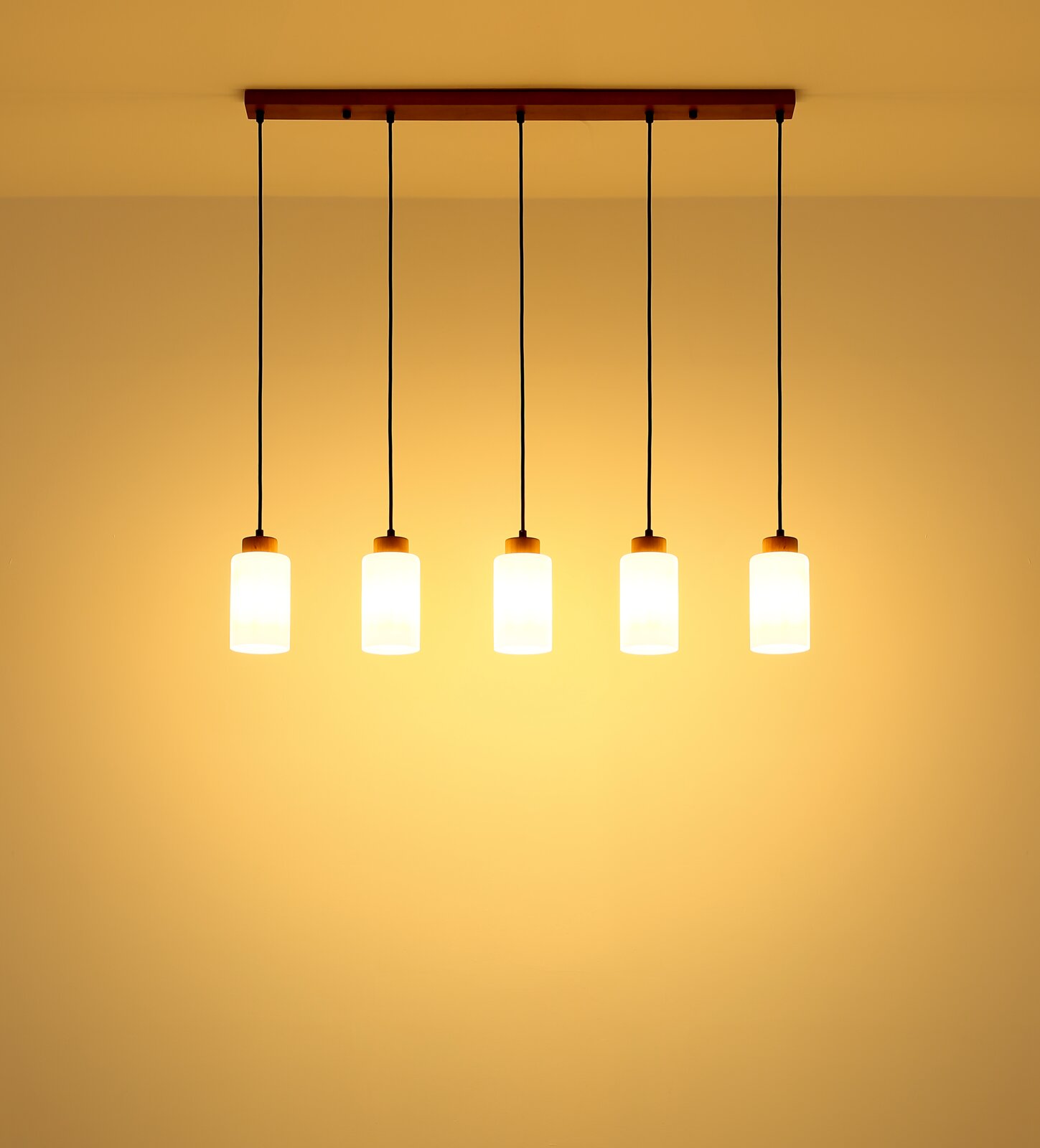 Moderne 5-flammige Pendelleuchte mit Holz-Deckenbalken, schwarzen Kabeln und zylindrischen weißen Glasschirmen, warm leuchtend, Frontalansicht von unten