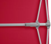 Nahaufnahme eines roten Sonnenschirms mit grauem Gestänge, seitliche Perspektive