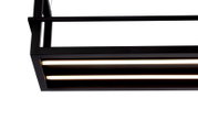 Close-up van een moderne LED-hanglamp in rechthoekig ontwerp met een zwart frame en warmwitte lichtstroken, gezien van onderaf.