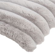 Nahaufnahme einer weichen, gestreiften Fellkissenhülle in hellgrauen Tönen.