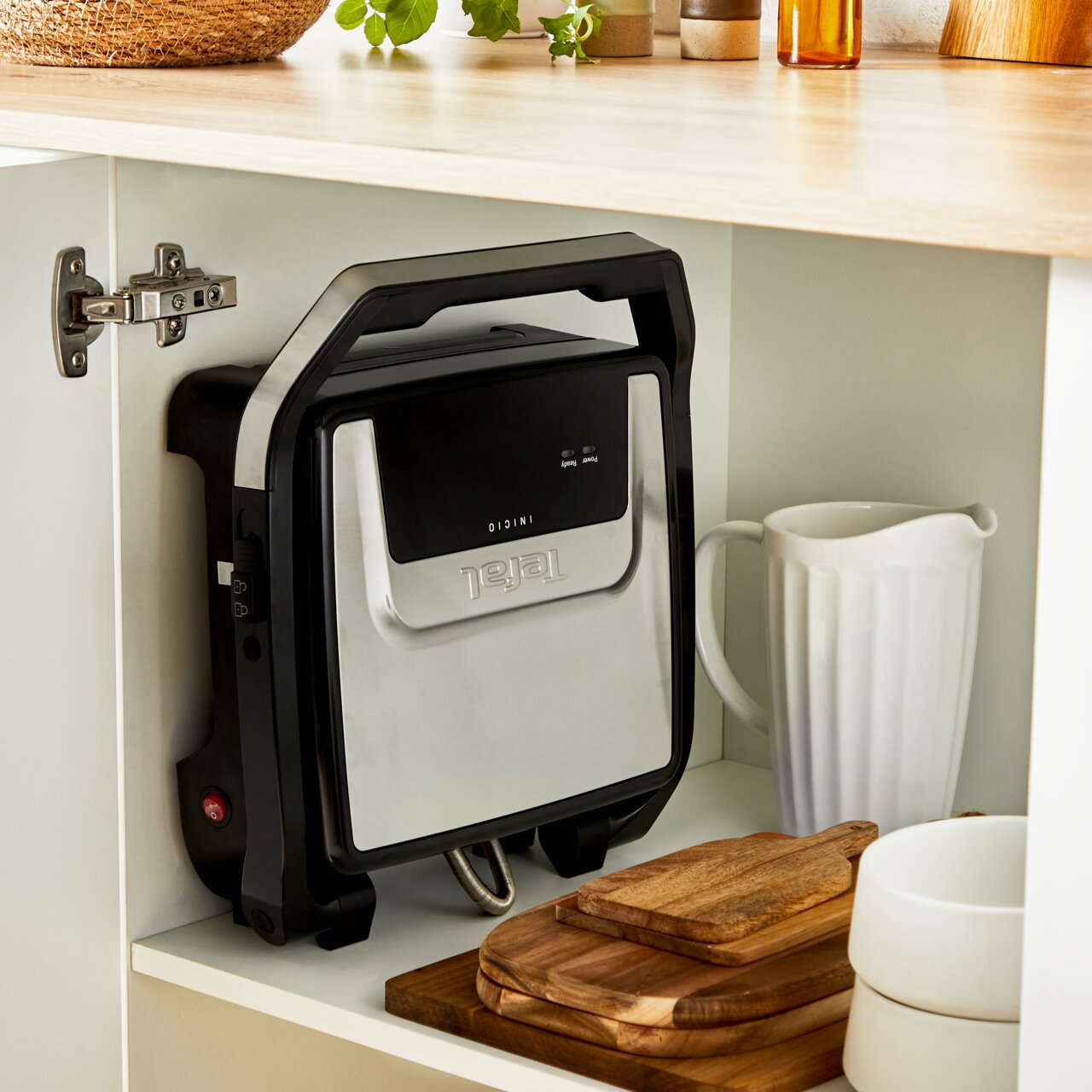 Contactgrill Classic GC271D in een keukenkast, verticaal opgeborgen naast keukengerei, gezien vanaf de zijkant.