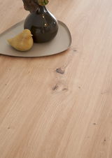 Nahaufnahme einer Holzoberfläche mit einer dekorativen Vase und einem kleinen Vogel aus Keramik auf einem Tablett.