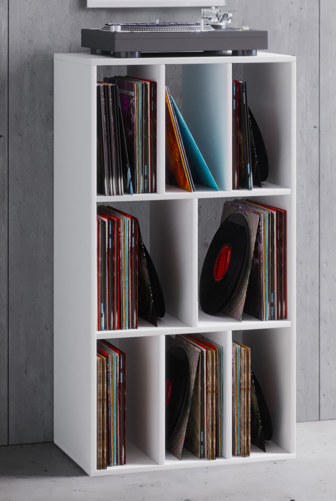 Weißes 3x2 Schallplattenregal mit sechs Fächern, gefüllt mit Vinylplatten; oben steht ein Plattenspieler, fotografiert in leicht schräger Frontansicht.