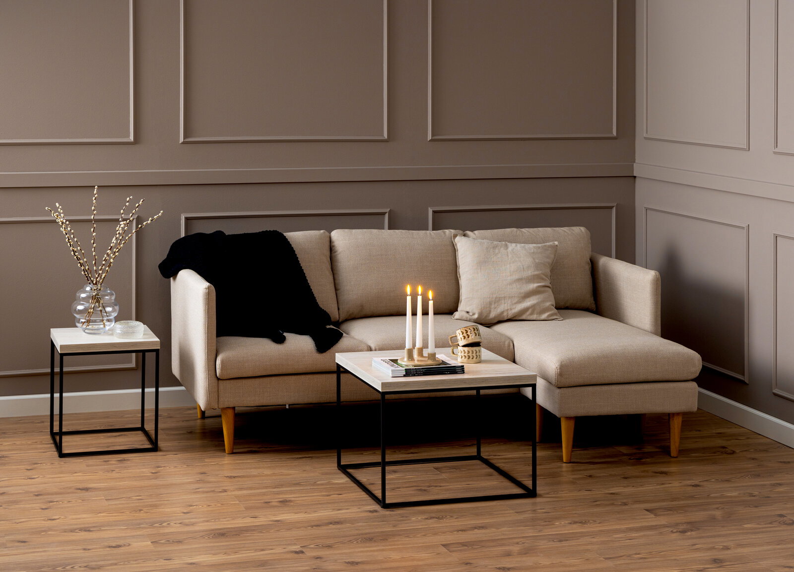 Livetastic Couchtisch BAROSSA Moderner Couchtisch mit hellem Holz und schwarzem Metallgestell, frontal vor einem beigen Sofa in einem stilvoll eingerichteten Wohnzimmer.