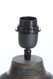 Nahaufnahme eines Lampenfußes mit schwarzer Fassung auf einem strukturierten, hölzernen Sockel, seitliche Perspektive.