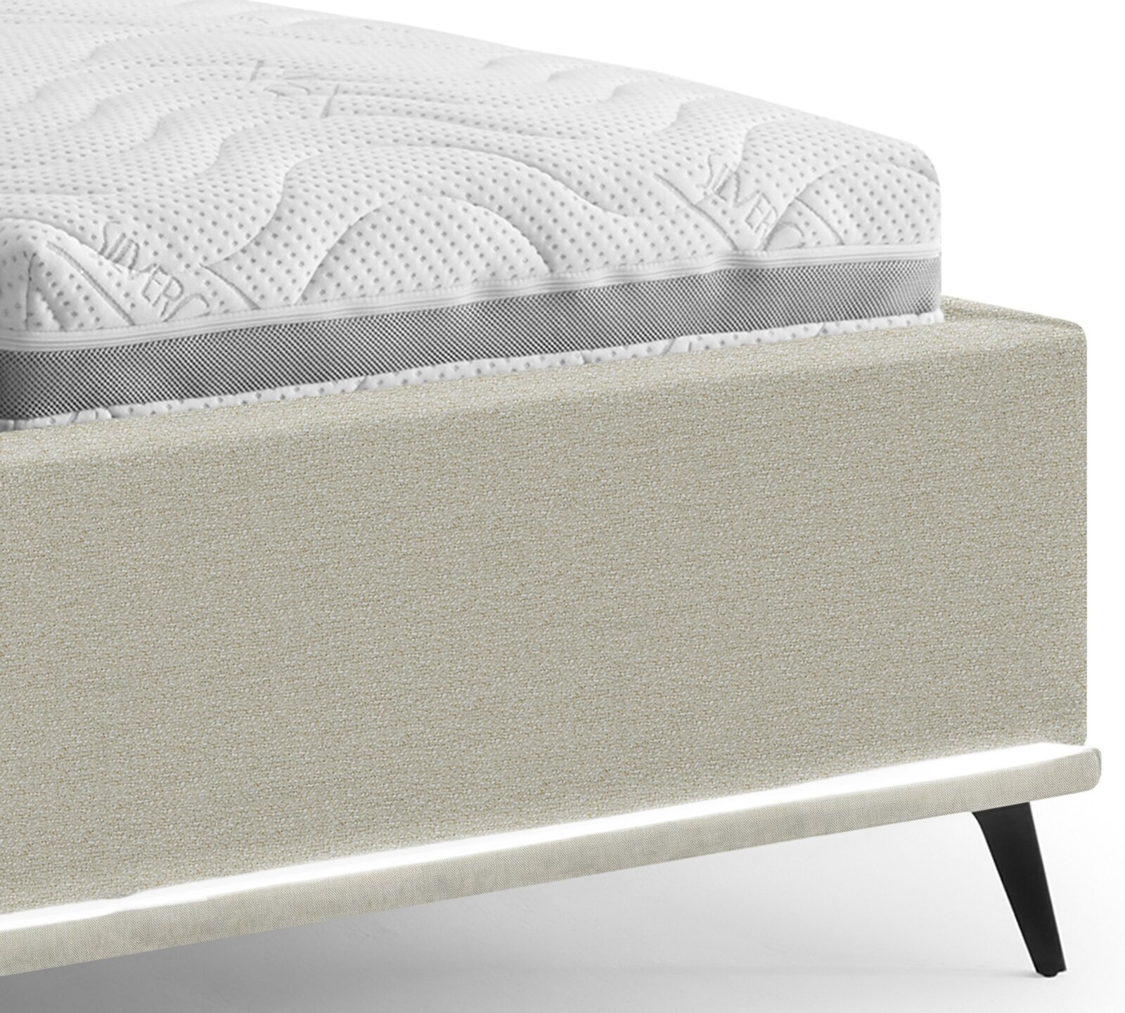 Detailansicht eines gepolsterten Bettrahmens in Beige mit weißer, gesteppten Matratze und grauem Seitenband, fotografiert aus seitlicher Perspektive leicht von oben.
