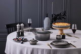 Elegante Tarte-Form 28cm Flint auf einem gedeckten Tisch mit einer frisch gebackenen Tarte, umgeben von stilvollem Geschirr und Dekorationen, aus der Vogelperspektive.