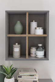 Wandregal mit vier Fächern, gefüllt mit dekorativen Gegenständen, aus frontaler Perspektive.