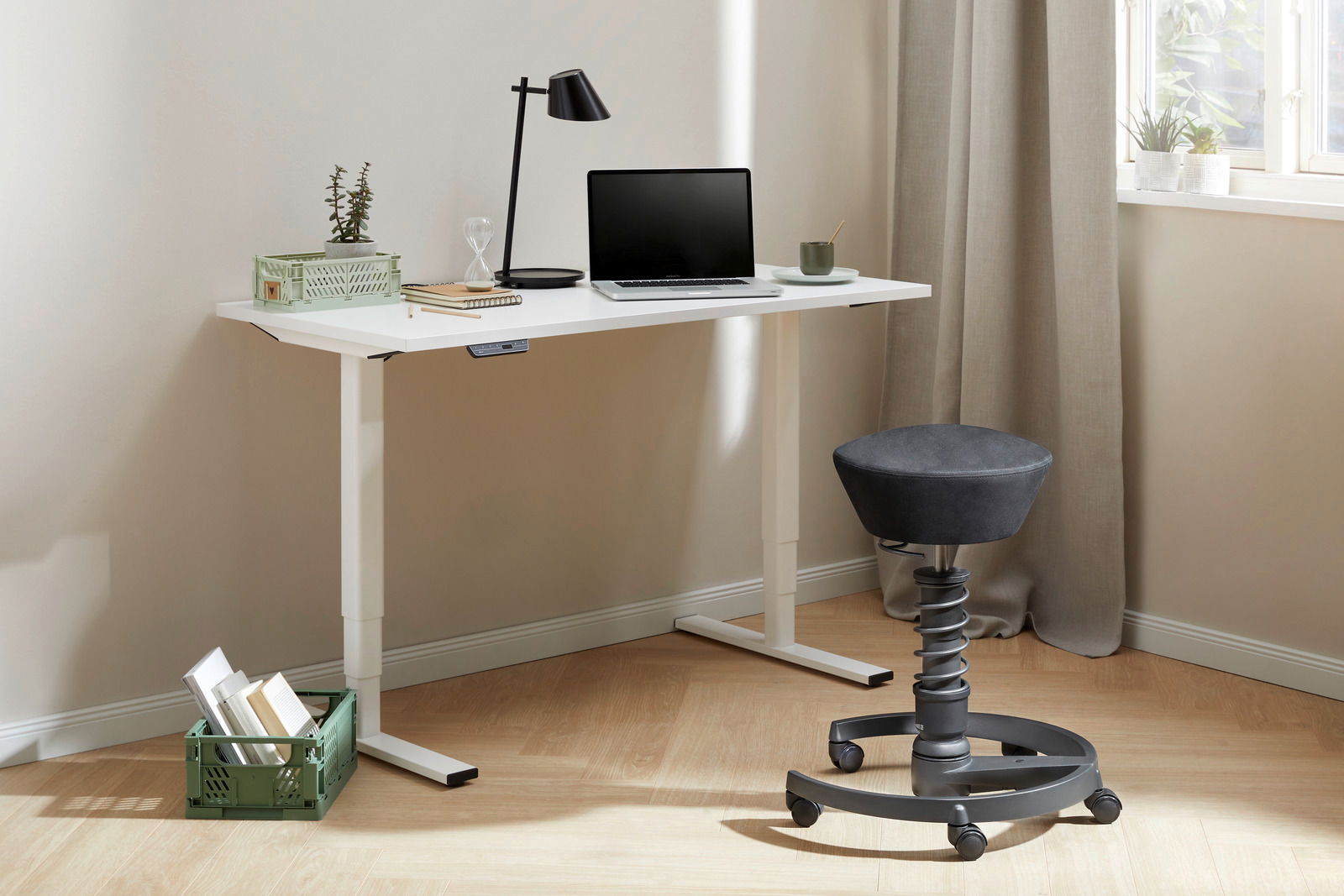 Moderner höhenverstellbarer E-Schreibtisch in Weiß mit Laptop, Lampe und Pflanzen, seitliche Perspektive.