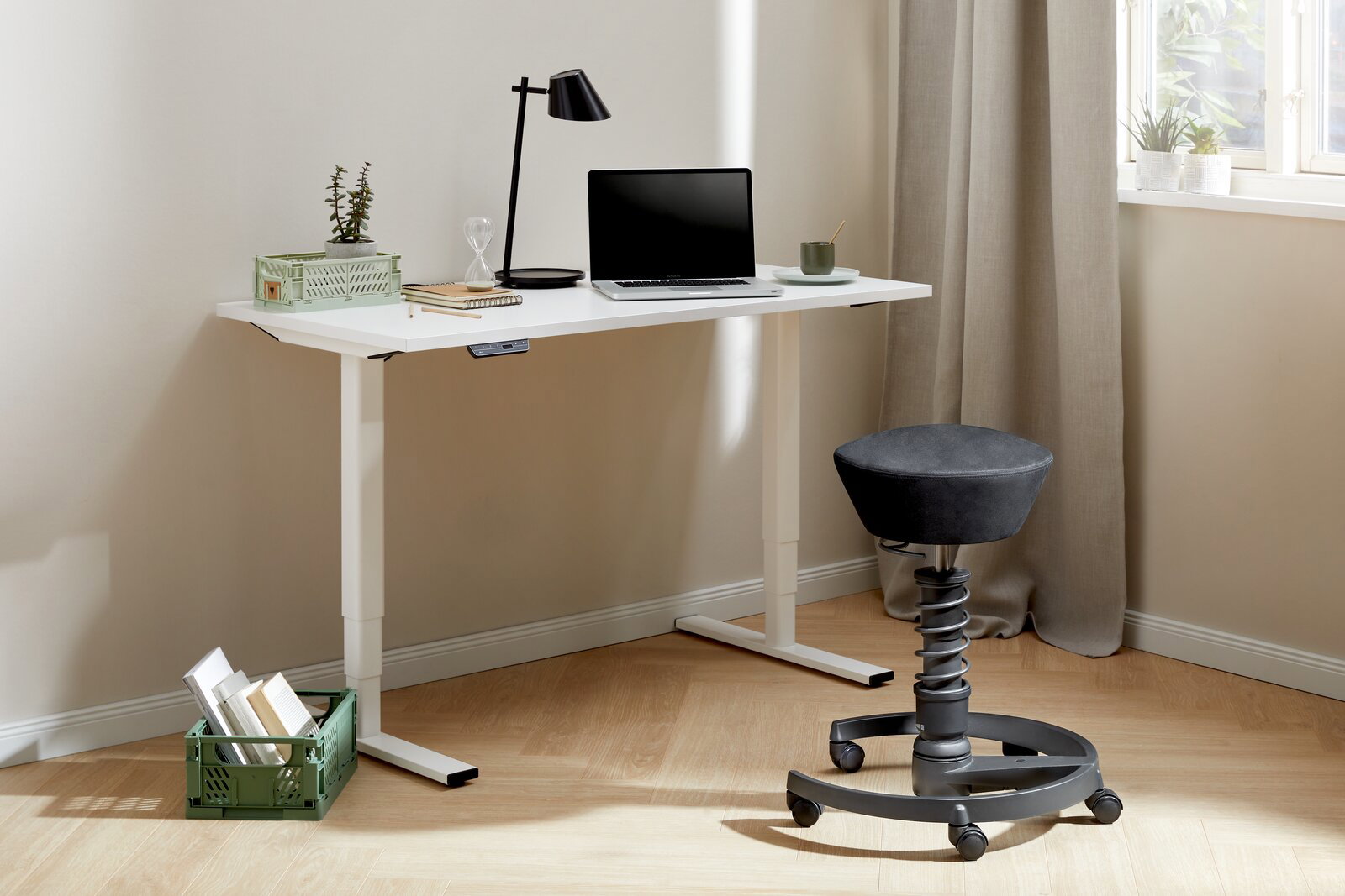 Moderner höhenverstellbarer E-Schreibtisch in Weiß mit Laptop, Lampe und Pflanzen, seitliche Perspektive.