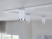 Drei weiße Schienenspots der Marke PAULMANN Tube URAIL an einer Decke montiert, seitliche Perspektive.