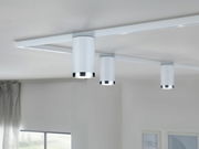 Drei weiße Schienenspots der Marke PAULMANN Tube URAIL an einer Decke montiert, seitliche Perspektive.