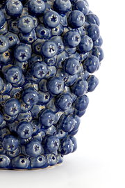 Nahaufnahme eines blauen, strukturierten Lampenfußes mit sternförmigen Details, seitliche Perspektive.