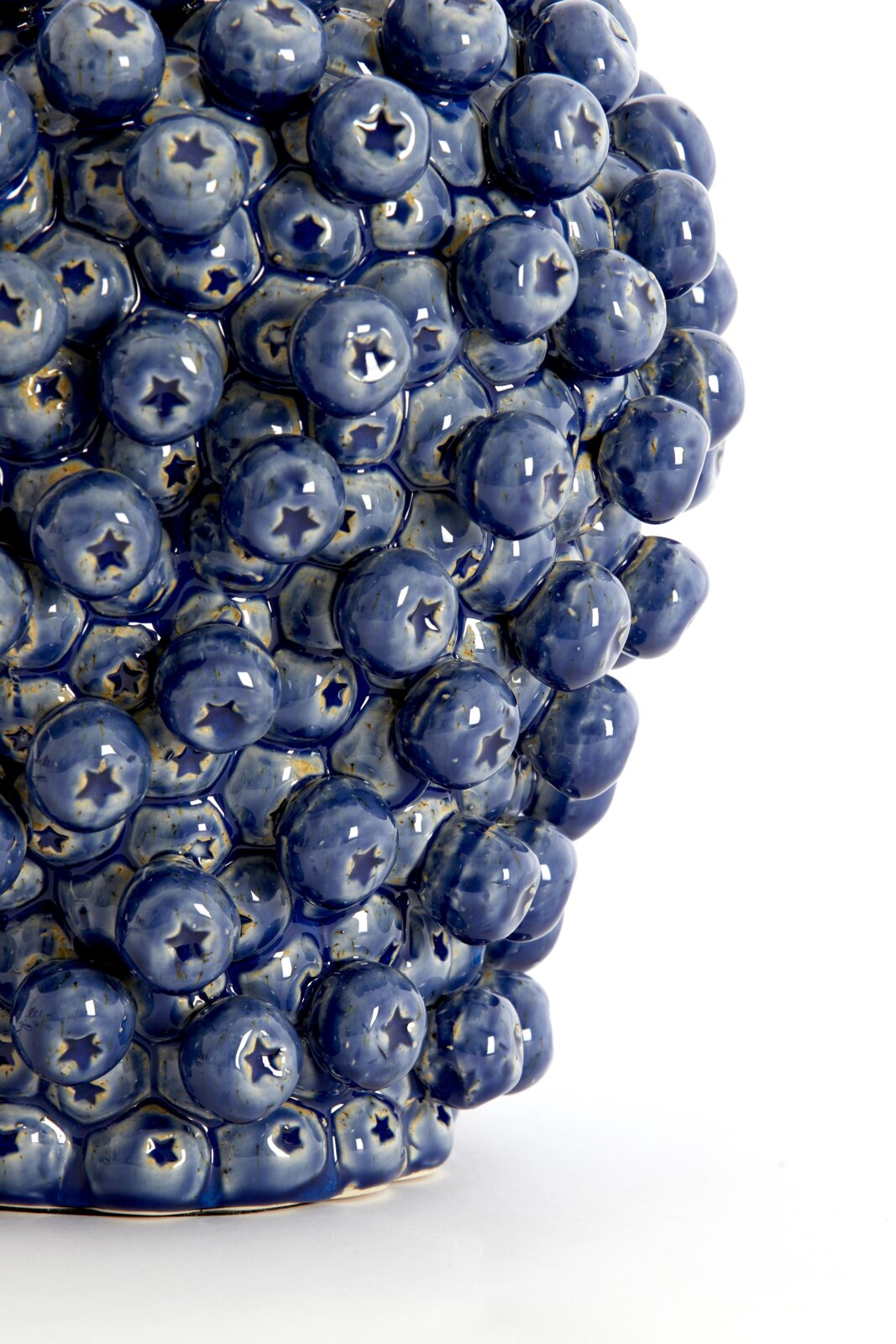 Nahaufnahme eines blauen, strukturierten Lampenfußes mit sternförmigen Details, seitliche Perspektive.