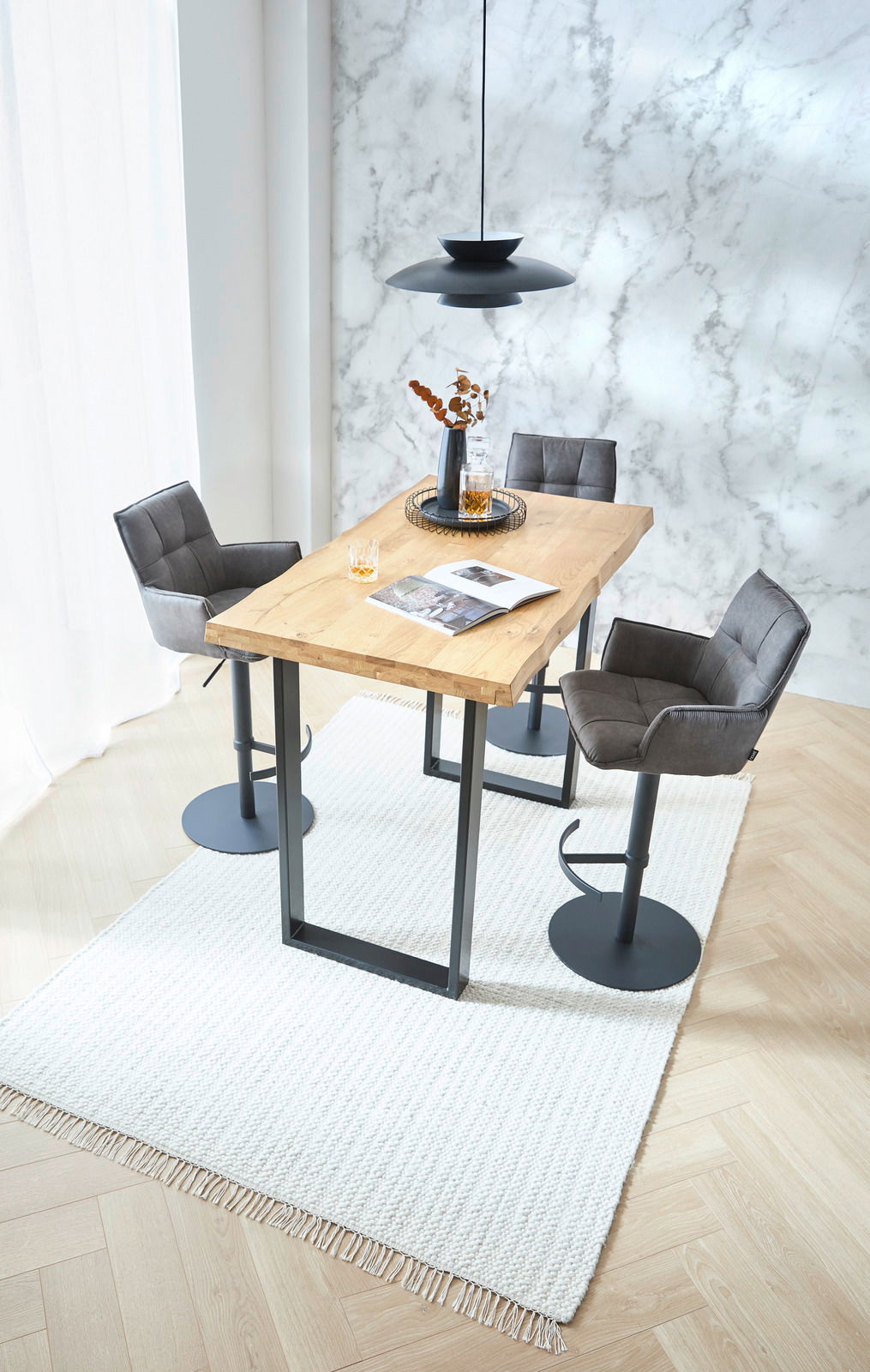 Moderne Barhocker in einem stilvollen Essbereich mit Holztisch und Marmortapete, Perspektive von oben.