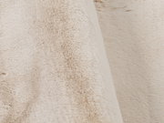 Nahaufnahme eines beigen Fellteppichs mit weicher, flauschiger Textur.