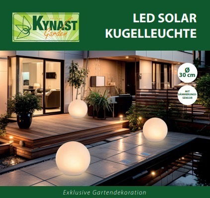 Solar Kugelleuchte 30cm im Garten bei Nacht, leuchtend auf einer Terrasse mit moderner Architektur im Hintergrund, seitliche Perspektive