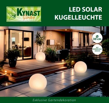 Solar Kugelleuchte 30cm im Garten bei Nacht, leuchtend auf einer Terrasse mit moderner Architektur im Hintergrund, seitliche Perspektive