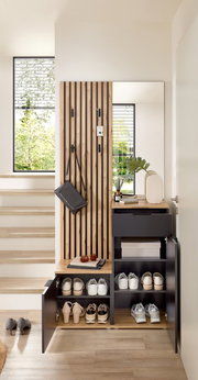 Compacte kapstok met houten en zwarte elementen, schoenenrek, spiegel en opbergvlak, gefotografeerd vanaf de voorkant.