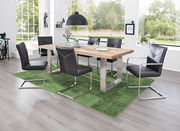 Moderner Essbereich mit einem großen Holztisch und sechs Freischwinger-Stühlen in einem hellen Raum mit großen Fenstern, Blick von der Seite.