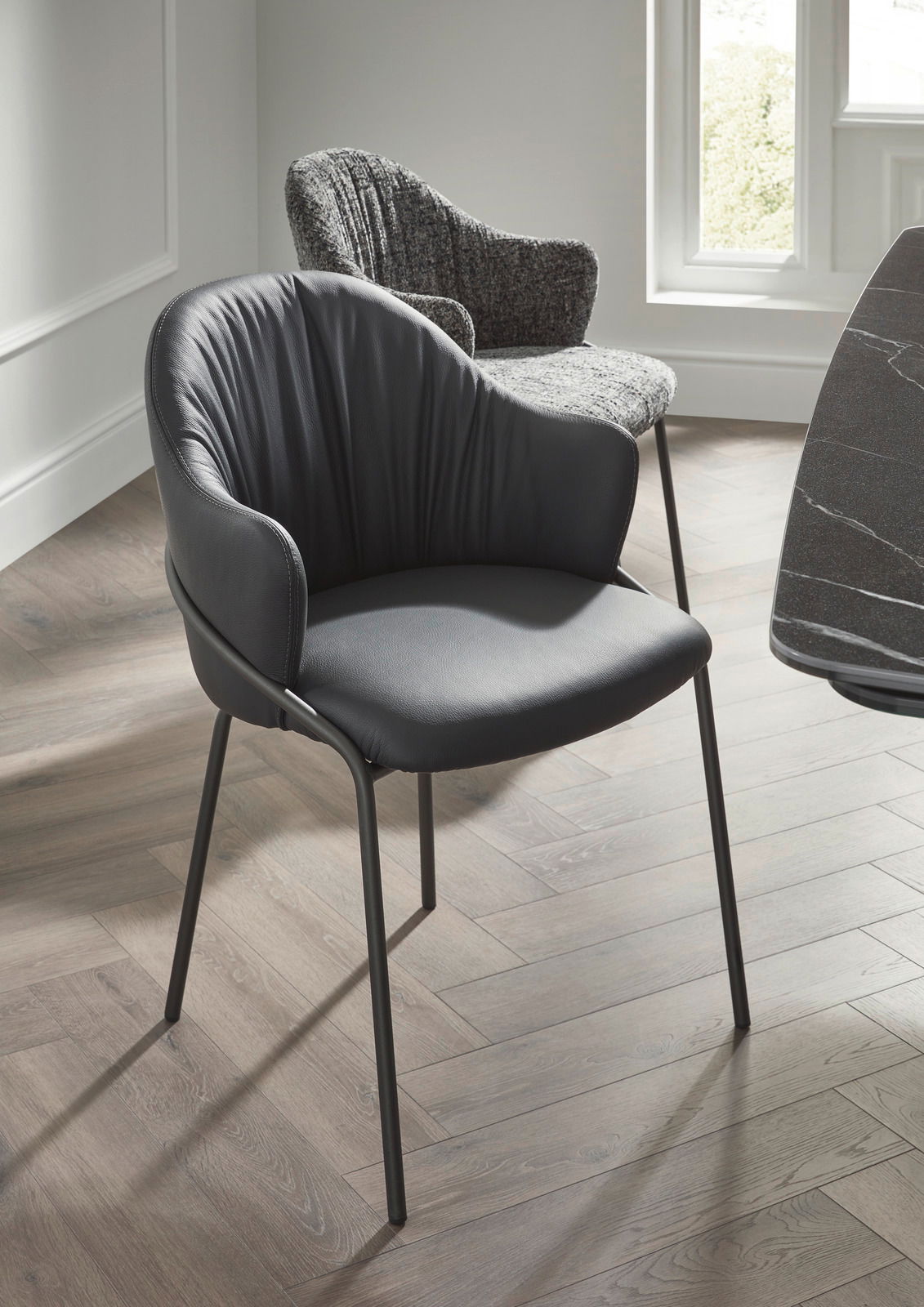 Moderner Armlehnstuhl aus schwarzem Leder mit Metallbeinen, seitliche Perspektive