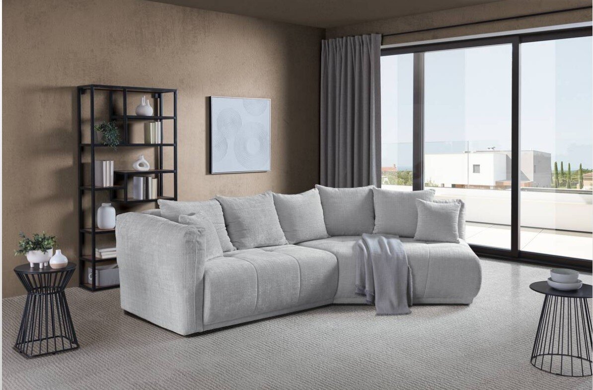 Hom´in Ecksofa Evita Moderne Rundecke in einem stilvollen Wohnzimmer mit Blick auf eine große Fensterfront. Die Couch ist in einem hellen Grauton gehalten und mit mehreren Kissen dekoriert.