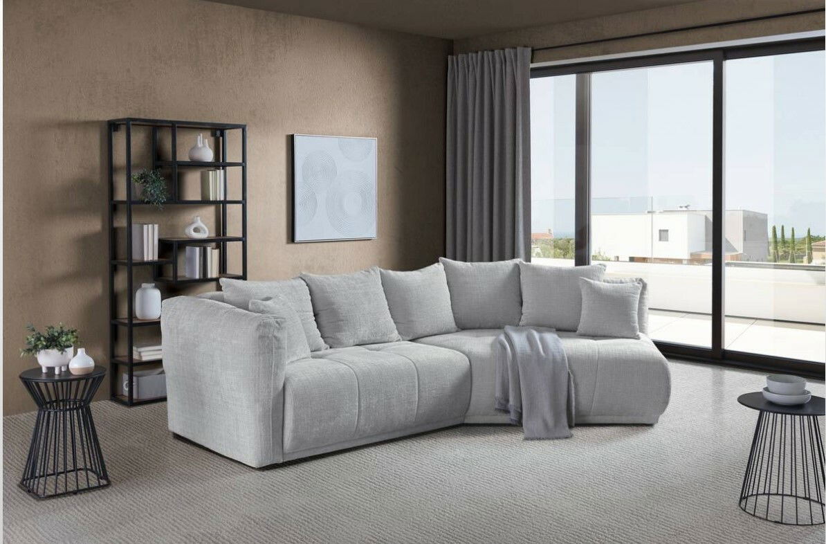 Moderne Rundecke in einem stilvollen Wohnzimmer mit Blick auf eine große Fensterfront. Die Couch ist in einem hellen Grauton gehalten und mit mehreren Kissen dekoriert.