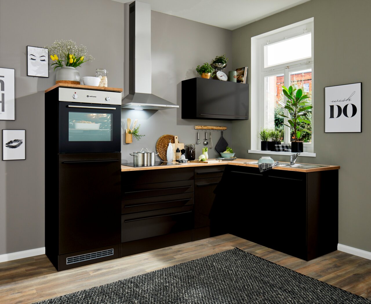 Moderne Küche mit Eckunterschrank in dunklem Design, fotografiert aus einer leicht erhöhten Perspektive, die den gesamten Raum zeigt.