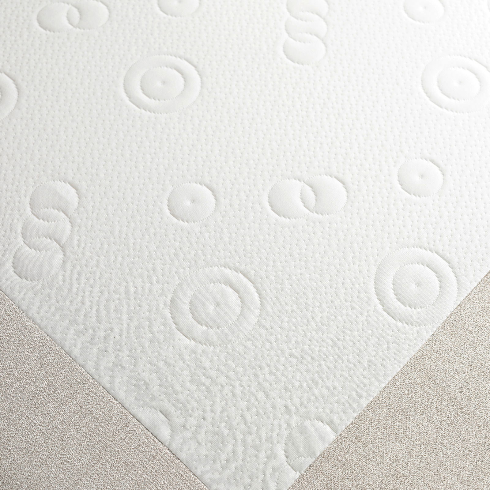 Nahaufnahme eines Funktionssofas mit strukturiertem, kreisförmigem Muster auf der Oberfläche, aus der Vogelperspektive.