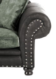 Nahaufnahme eines Megasofas mit runder Armlehne, schwarzem Lederbezug und grünen Kissen, seitliche Perspektive.