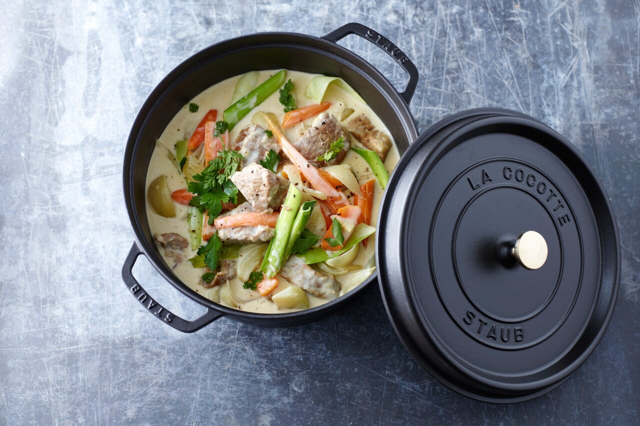 Runder Bräter Cocotte 28cm von oben mit geöffnetem Deckel, gefüllt mit einem bunten Eintopf aus Fleisch und Gemüse.