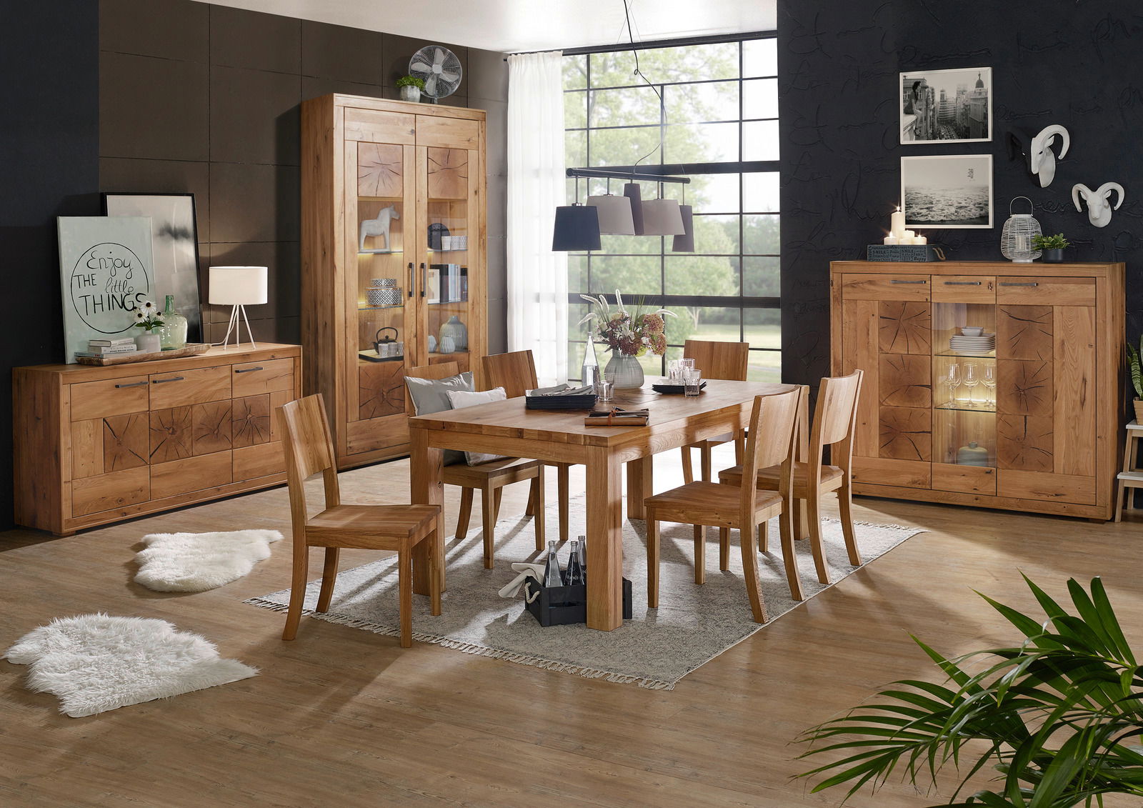 Esszimmer mit Holzmöbeln der Serie Landscape MERAN, bestehend aus einem großen Esstisch, Stühlen, einem Sideboard und einem Highboard, in einem modernen Raum mit großen Fenstern und stilvoller Dekoration. Perspektive: Frontalansicht.