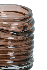 Nahaufnahme eines gerippten, braunen Glas-Teelichthalters mit glänzender Oberfläche.