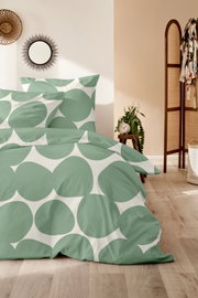 Bettwäsche-Set in Grün und Weiß mit großem Kreismuster, auf einem Bett in einem stilvoll eingerichteten Schlafzimmer, aus der Perspektive von vorne fotografiert.