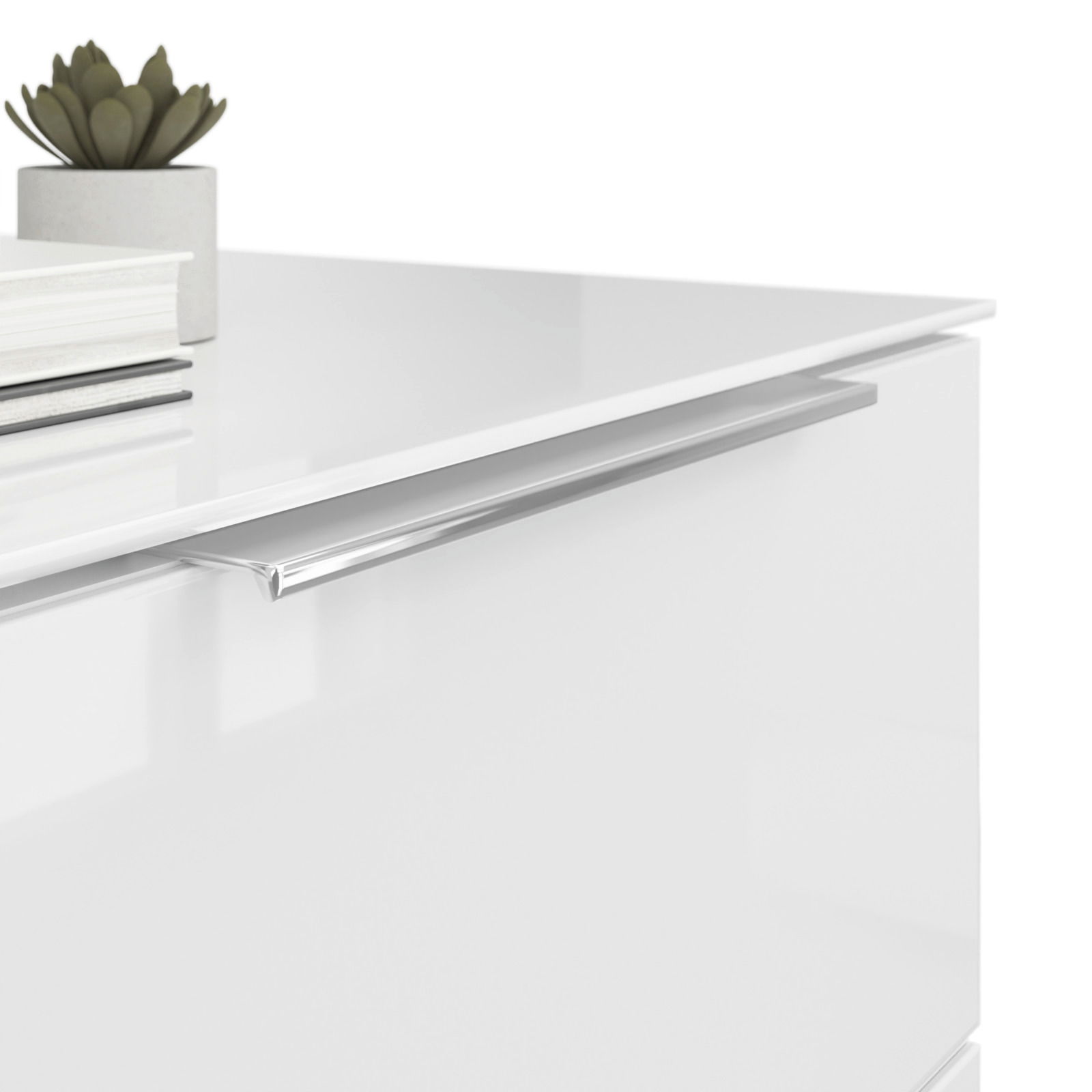 Nahaufnahme einer weißen Nachtkommode mit glänzender Oberfläche, silbernem Griff und Dekorationen wie einem kleinen Pflanzentopf und Büchern auf der Oberseite, aus seitlicher Perspektive.
