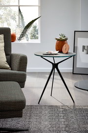 Moderner Beistelltisch mit schlankem, dreibeinigem Metallgestell und runder Tischplatte, seitliche Perspektive.