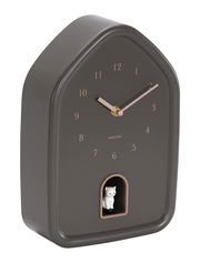 Moderne Wanduhr in Hausform mit braunem Gehäuse und roségoldenen Zeigern, seitliche Perspektive, mit einer kleinen weißen Katzenfigur in einer Öffnung unten.