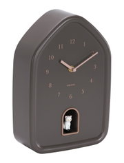 Moderne Wanduhr in Hausform mit braunem Gehäuse und roségoldenen Zeigern, seitliche Perspektive, mit einer kleinen weißen Katzenfigur in einer Öffnung unten.