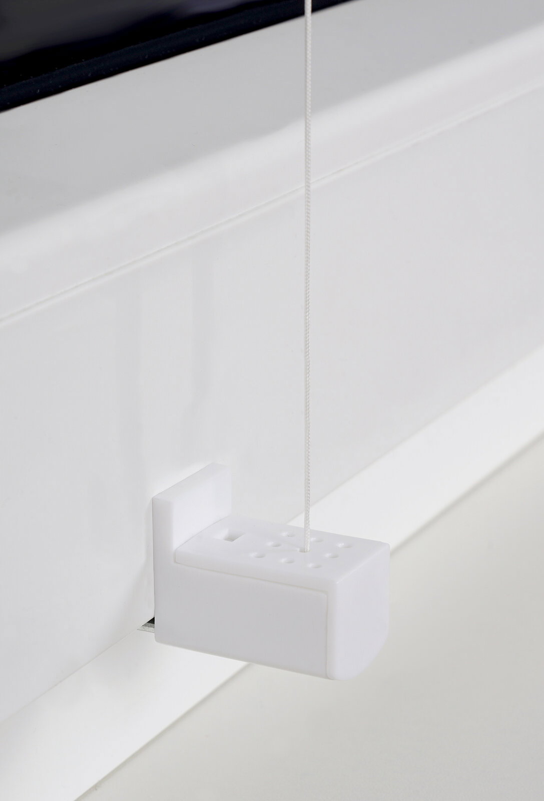 Nahaufnahme eines weißen Plissee-Mechanismus mit Schnur, seitliche Perspektive