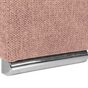 Nahaufnahme einer rosa strukturierten Stoffoberfläche mit einem silbernen Metallfuß, perspektivisch von der Seite aufgenommen.