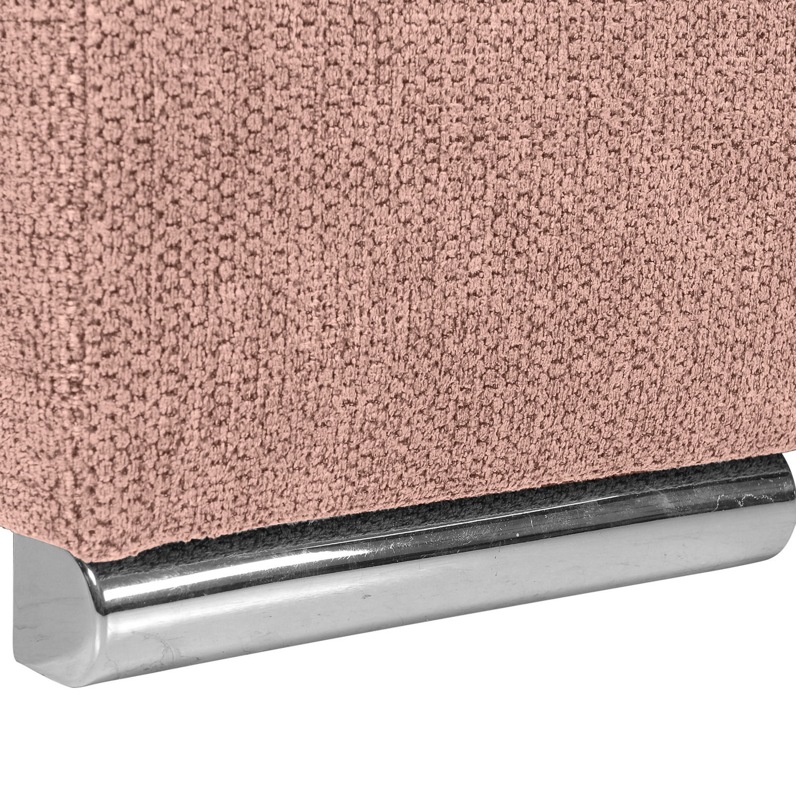 Nahaufnahme einer rosa strukturierten Stoffoberfläche mit einem silbernen Metallfuß, perspektivisch von der Seite aufgenommen.