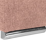 Nahaufnahme einer rosa strukturierten Stoffoberfläche mit einem silbernen Metallfuß, perspektivisch von der Seite aufgenommen.